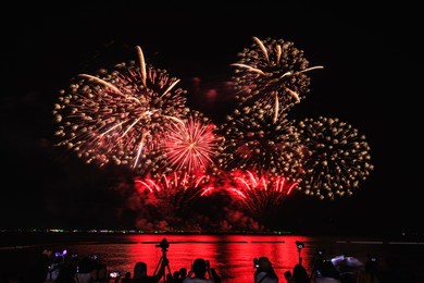 pattaya, chonburi, thailand, - november beautiful lights at the night, colorful fireworks, at pattaya international fireworks festival and silhouette group of people tourist 