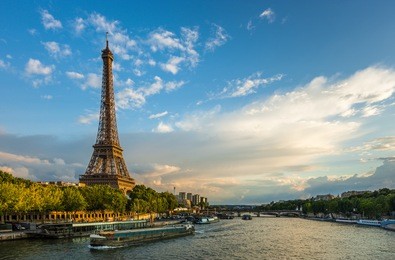 beautiful sunset over eiffel tower and seine river with puffy clouds, paris, france