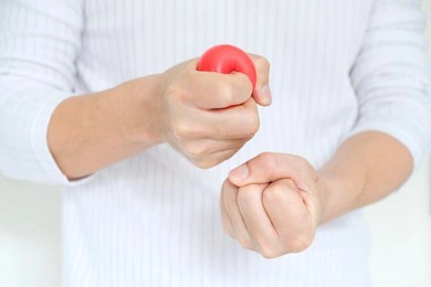 hands of man with a gentle personality he exhibits stressful behavior from work, and he squeezes the yellow ball expressing emotion, anger, displeasure. medical concepts and emotional regulation