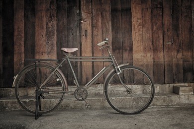 vintage bicycle leaning against wooden wall