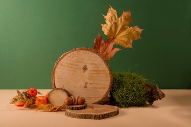 set of wooden podiums, decor and autumn leaves against beige and green background. good for perfume, jew or cosmetic product presentation.