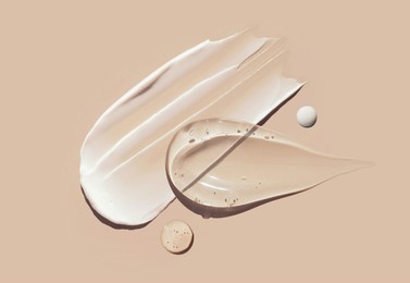 cosmetic smears of creamy texture on a pastel beige background