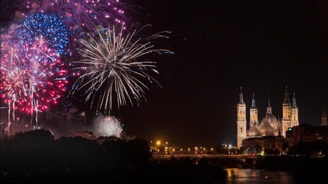 photograph of the fireworks at the end of the fiestas del pilar 2022 in zaragoza, with the basilica del pilar in the background and the ebro river, spain.
