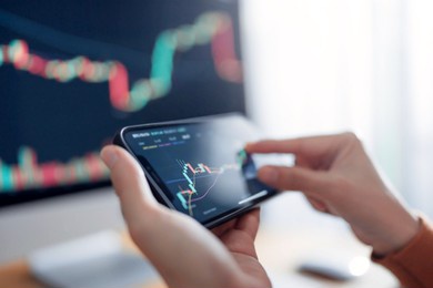 closeup graph - woman is checking bitcoin price chart on digital exchange on smartphone, cryptocurrency future price action prediction.