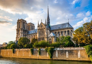 gorgeous sunset over notre dame cathedral with puffy clouds, paris, france