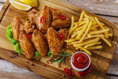 fried chicken wings with red sauce and french fries