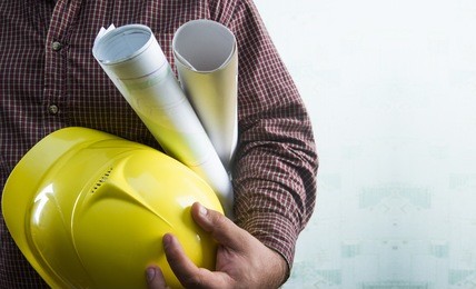 no face unrecognizable person construction worker man holding in hands blueprint and yellow helmet on green texture wall with wallpaper background empty copy space for inscription