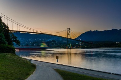 lions gate bridge at sunset with a passing ship