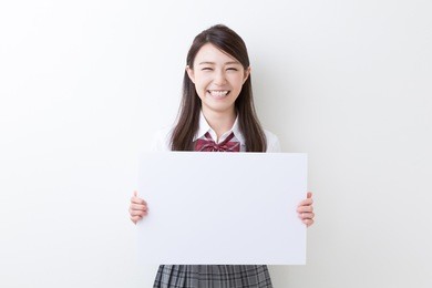 beautiful young asian school girl holding blank white board