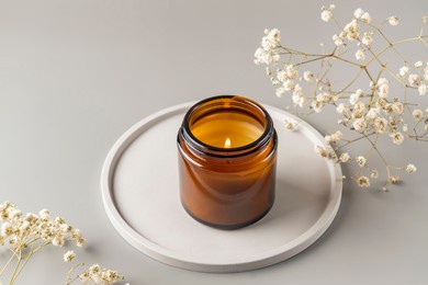 handmade candle from paraffin and soy wax in glass jar on concrete tray. candle making. minimalism. luxurious white tray decoration, home interior decor with burning aroma candle with white dry flower