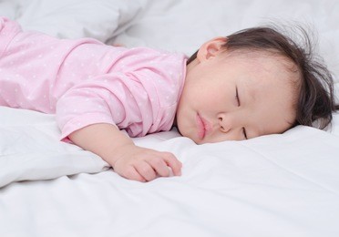 asian little girl sleeping in a bed