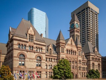 view of the old city hall of toronto, canada against modern buildings