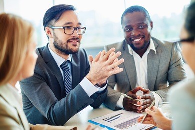 happy asian businessman looking at colleague during discussion