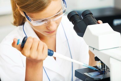 beautiful woman in a laboratory working with a microscope.