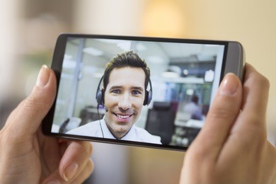 closeup of a female hand holding a smart phone during a skype video