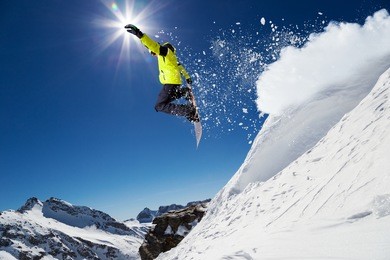 free rider with snowboard jumping from hill