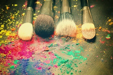 makeup brushes on background with colorful powder. make-up background 