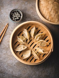 chinese dumplings on a steamer, soy sauce and chopsticks. traditional chinese, asian dish. dim sum dumplings steamed in a steamer, top view