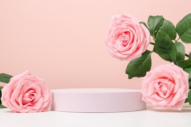 empty podium with pink roses on pastel pink background to display products, gift or cosmetics.