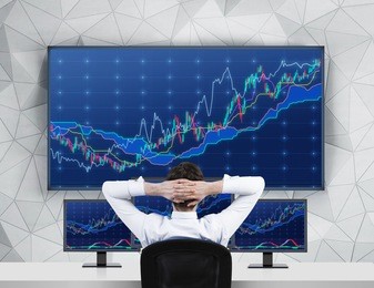 chilling trader in front of forex screens 