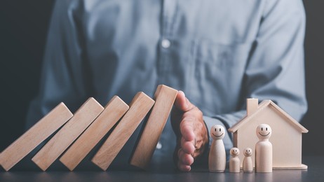human hand blocking wooden blocks,represents protection and protection of safety,concept of insurance management planning to ensure both health and financial safety,property and family risk reduction