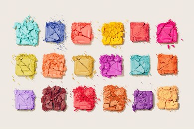 beauty product multi-colored eyeshadows for makeup as colorful pattern on beige background, flat lay vivid colors swatch eyeshadows, cosmetic textures, professional color pallete, top view pattern