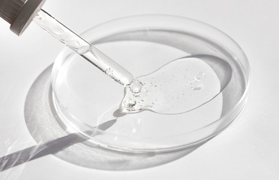 close-up of pipette and petri dish with facial serum gel