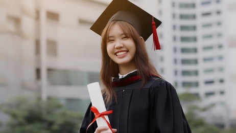 happy asian girl in college student gown graduate from academy. 