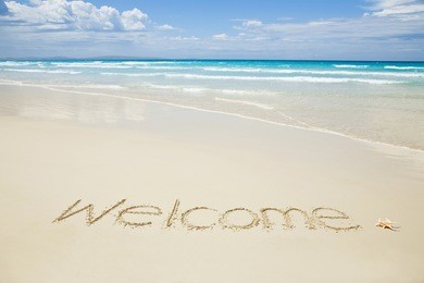 welcome written on a tropical beach