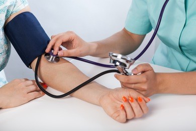 closeup of doctor measuring blood pressure of woman