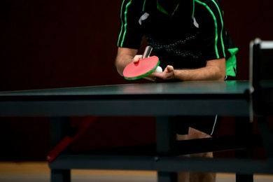 table tennis player serving, holding ball in hand