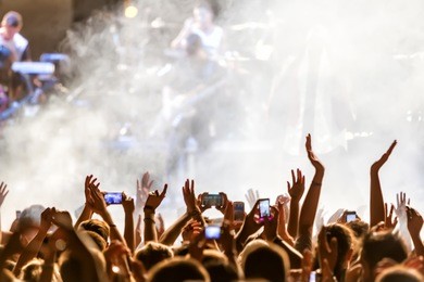 people taking photographs with touch smart phone during a music entertainment public concert