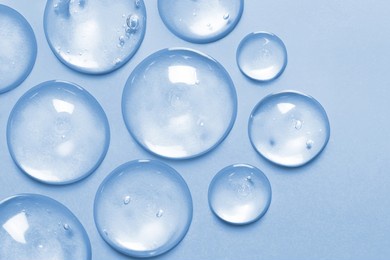 cosmetic serum gel beauty drop on blue color background. skincare beauty product with bubbles texture.	
