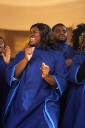 group of christian gospel singers praising lord jesus christ. church filled with spiritual message uplifting hearts. music brings peace, hope, love. song spreads blessing, harmony in joy and faith.