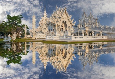 beautiful ornate white temple located in chiang rai northern thailand. wat rong khun (white temple), is a contemporary unconventional buddhist temple.buddhist and hindu motifs.