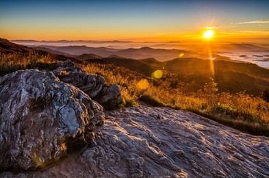 a golden fall sunrise over the blue ridge mountains from atop black balsam bald in north carolina.