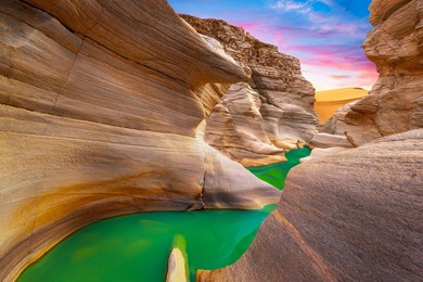 beautiful nature landscape with colorful sunset in desert. colorful nature scenery in mountain canyon. nature travel in stunning summer landscape. view of the stream flowing from the valley.