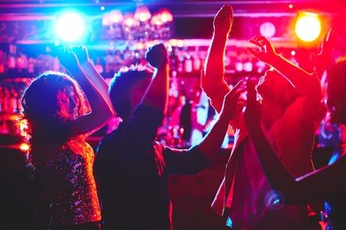 group of dance lovers enjoying disco in nightclub