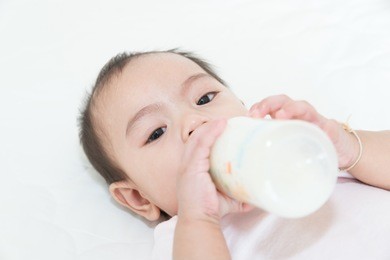 asian baby infant eating milk from bottle