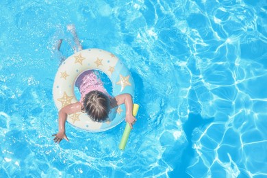a small child swimming with a balloon, view from above.  summer blue water sunny day