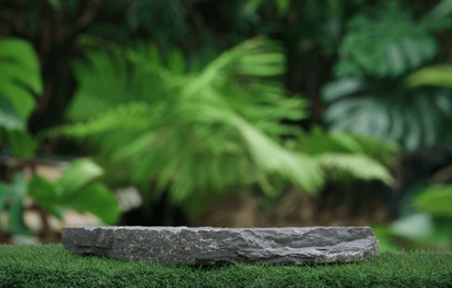 stone podium table top outdoors blur green monstera tropical forest plant nature background.beauty cosmetic healthy natural product placement pedestal display,spring or summer jungle paradise.