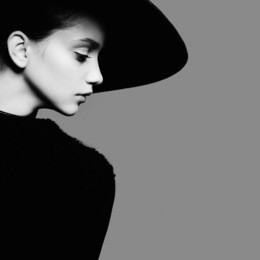 portrait of beautiful girl in hat in profile, posing in studio, black and white photography