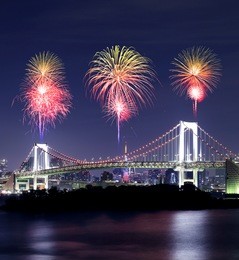 fireworks celebrating over tokyo rainbow bridge at night, odaiba, japan