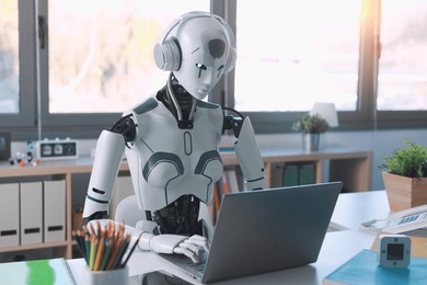a humanoid robot works in an office on a laptop to listening music in  headphone, showcasing the utility of automation in repetitive and tedious tasks.