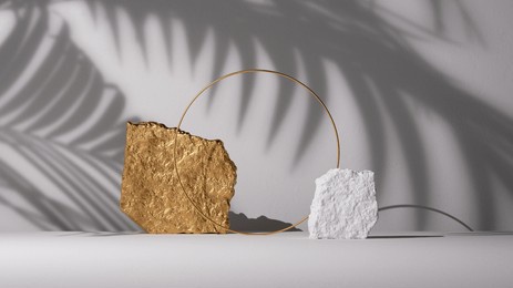 3d render, abstract background with tropical leaves shadow, rocks, stone ruins and round golden arch. minimalist scene with cobblestones, showcase for product presentation