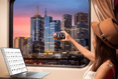 asian traveller woman take a cityscape photo by her smartphone on the train seat between working by computer notebook and on her travel trip
