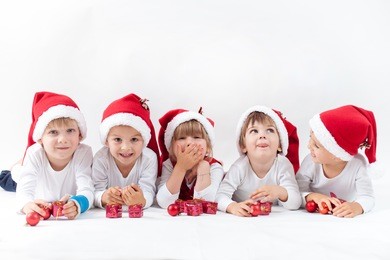 adorable kids with santa hat, smiling at the camera, isolated on white background