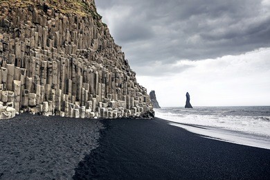 the black sand beach of reynisfjara and the mount reynisfjall from the dyrholaey promontory in the southern coast of iceland.