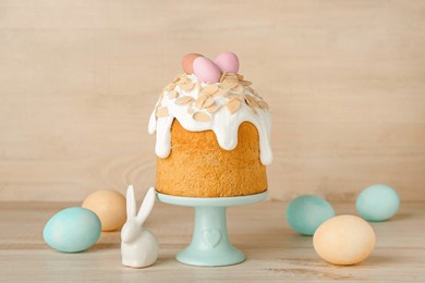 stand with easter cake, painted eggs and bunny on wooden background