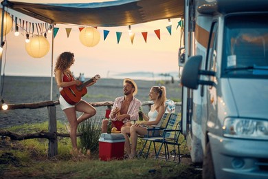 group of friends having fun camping by the sea together